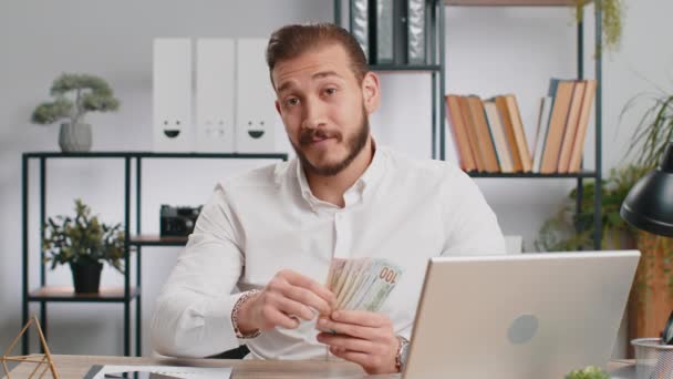 Young middle eastern boss business man showing money dollar cash gives to you wages salary, satisfied with good work. Success, wealth, investment. Freelancer guy at office workplace looking at camera - Footage, Video