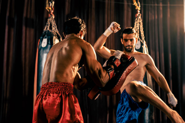 Boxer asiático e caucasiano Muay Thai desencadear ataque pontapé na sessão de treinamento de boxe feroz, entregando chutando greve para treinar sparring, mostrando técnica Muay Thai boxe e habilidade. Impulso - Foto, Imagem
