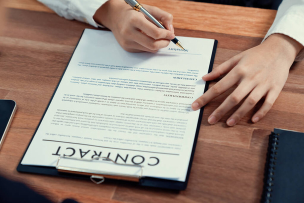 Closeup hand signing contract document with pen, sealing business deal with signature. Businesspeople finalizing business agreement by writing down signature on contract paper. Enthusiastic - Foto, Imagem