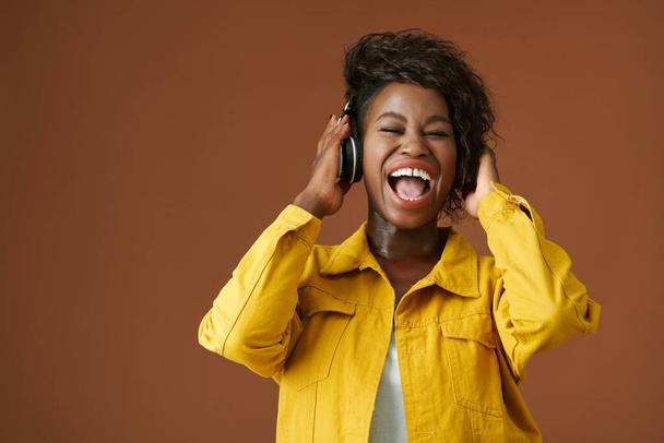 Młoda kobieta w słuchawkach krzyczy podczas słuchania świetnej muzyki - Zdjęcie, obraz