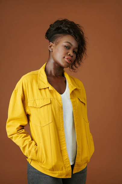 Retrato de mujer negra joven confiada en chaqueta amarilla denim mirando a la cámara - Foto, Imagen