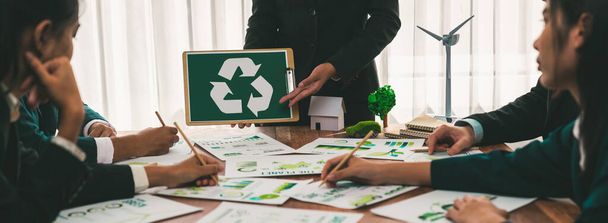Ryhmä liikemiehiä suunnittelee ja keskustelee kierrätyksestä vähentää uudelleenkäyttöä politiikan symboli toimistossa kokoushuoneessa. Vihreä liike-elämän yritys, jolla on ympäristöystävällinen jätehuollon sääntelykonsepti. - Valokuva, kuva