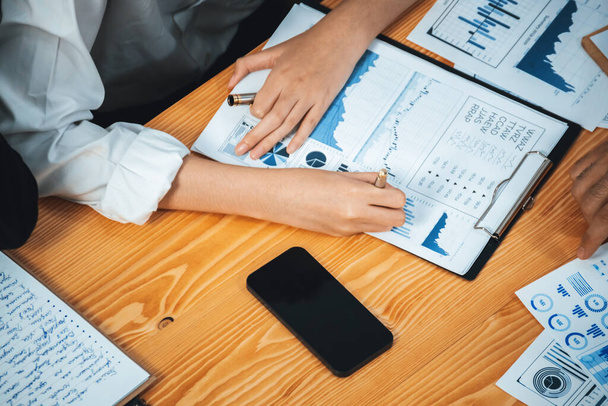 Diverse group of business analyst team analyzing financial data report paper on office table. Chart and graph dashboard by business intelligence analysis for strategic marketing planning Meticulous - Photo, Image