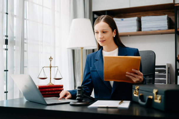 Caucasian lawyer woman at office desk with laptop and brown folder with documents,  - Фото, зображення