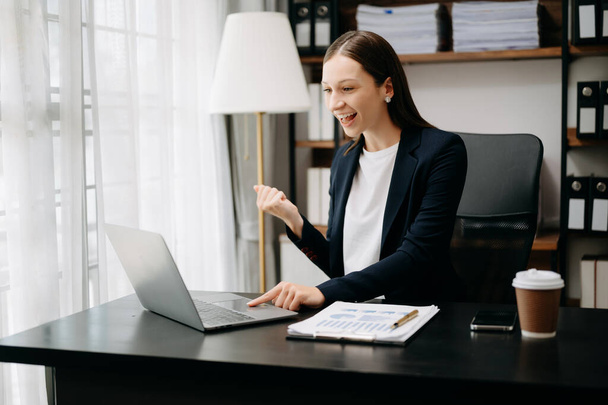 Caucasian business woman expressing happiness with hands while having video call on laptop  - Photo, Image