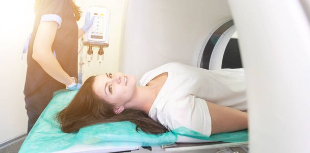 Técnico de tomografia computadorizada com vista para o paciente durante a preparação para o procedimento. Mulher paciente indo em tomógrafo - Foto, Imagem