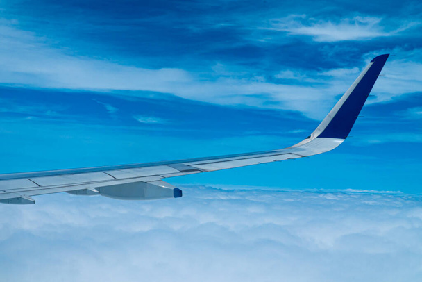 Vista del paisaje nuboso desde la ventana de un avión. Fondo cielo azul con diminutas nubes. - Foto, Imagen