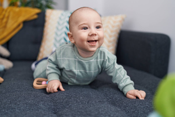 Adorable caucasian baby crawling on sofa at home - Photo, Image