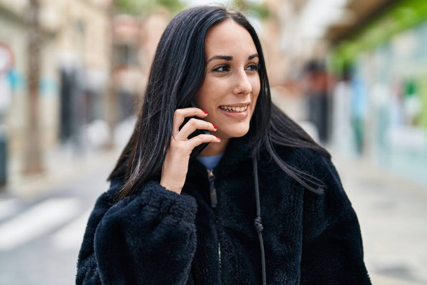 Young caucasian woman smiling confident talking on smartphone at street - Photo, Image