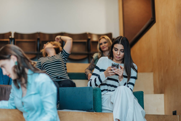 Přední pohled fotografie brunetky žena zvedání průzkumu na mobilním telefonu během setkání v práci - Fotografie, Obrázek
