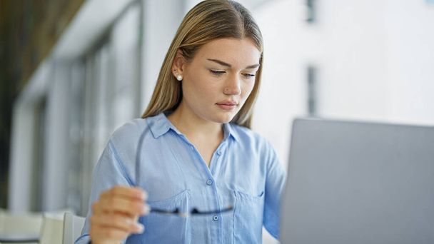 Fiatal szőke nő üzleti dolgozó laptoppal dolgozik az irodában - Fotó, kép