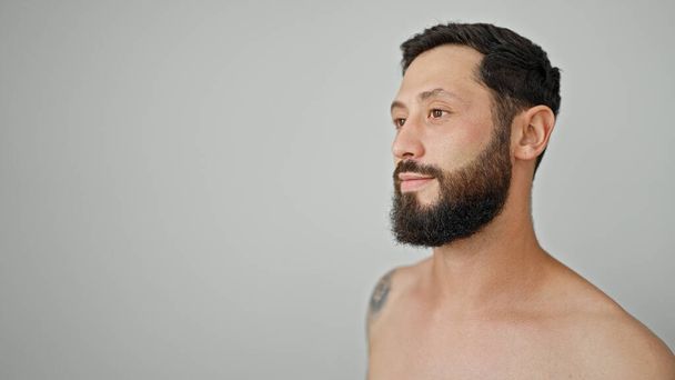 Jeune homme hispanique debout torse nu regardant sur le côté sur fond blanc isolé - Photo, image