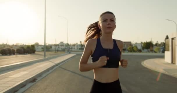 Stile di vita di una donna che fa jogging al mattino vicino alla casa sulla strada. Sport attivi e cardio. Filmati 4k di alta qualità - Filmati, video