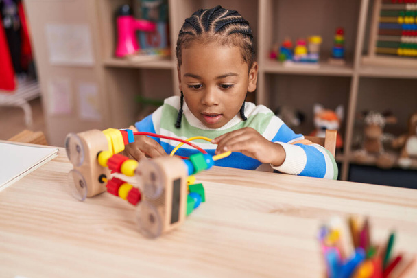 Afrykański amerykański chłopiec gra z bloków gry siedzi na stole w przedszkolu - Zdjęcie, obraz