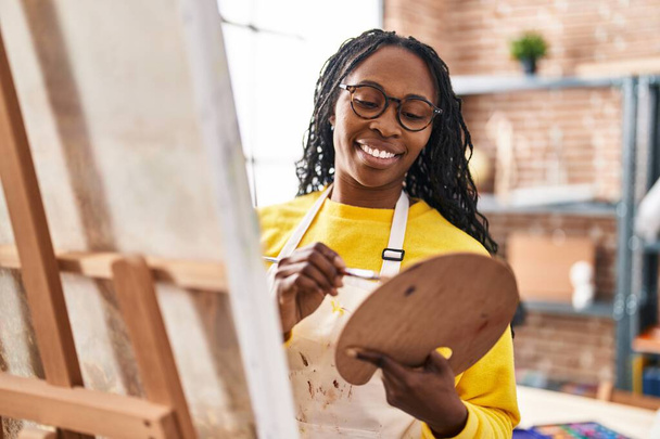 Afrikkalainen amerikkalainen nainen taiteilija hymyilee luottavainen piirustus art studio - Valokuva, kuva