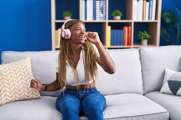 African american woman listening to music singing song at home - Photo, Image