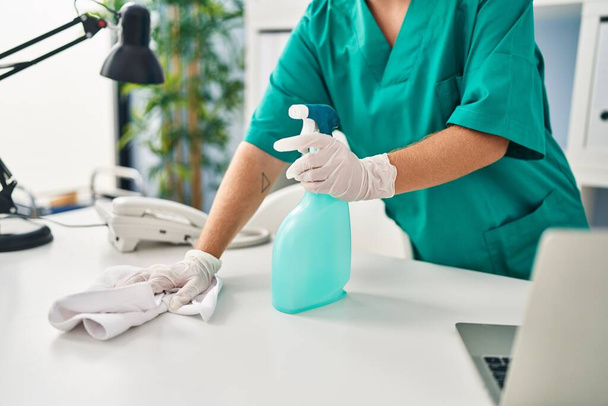 Young beautiful hispanic woman cleaning table at clinic - Photo, image