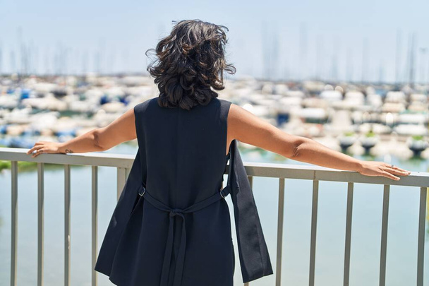 Young beautiful hispanic woman standing on back view at seaside - Fotografie, Obrázek