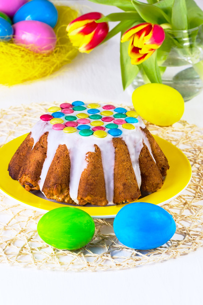 Easter cake with white glaze on a yellow plate - Zdjęcie, obraz