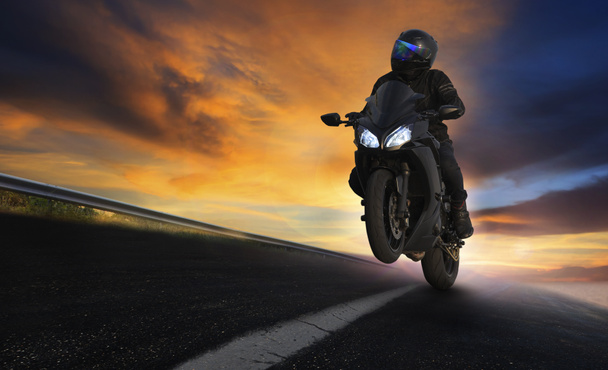 молодий чоловік їде на мотоциклі по асфальтовій дорозі з професіоналом
 - Фото, зображення