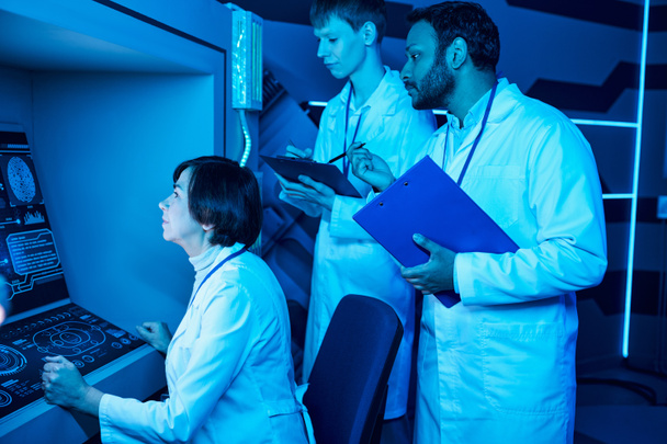 Дослідження завтра: три вчені співпрацюють поблизу футуристичного комп'ютера в науковому центрі - Фото, зображення