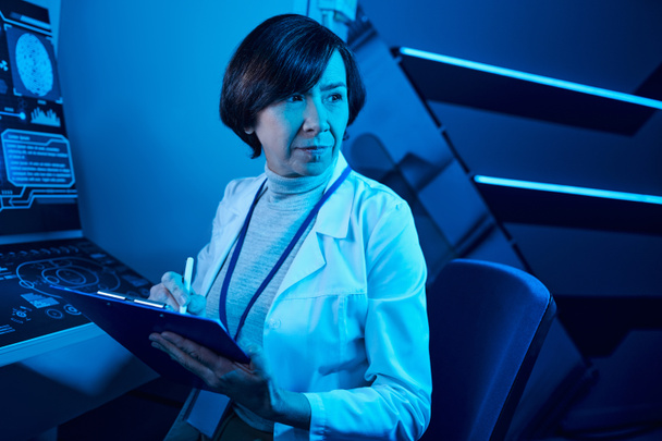 Γυναίκα Επιστήμονας καταγράφει τα δεδομένα και τα πρότυπα στο μελλοντικό επιστημονικό κέντρο - Φωτογραφία, εικόνα
