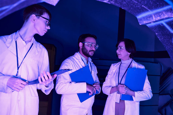 Collaborazione futuristica: gli scienziati di varie epoche convergono nel centro scientifico Neon-Lit - Foto, immagini