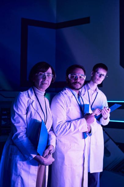 未来主義的フォーカス:ヘッドショットスタンスに従事する3人の科学者,サイエンスセンターでガス処刑. - 写真・画像