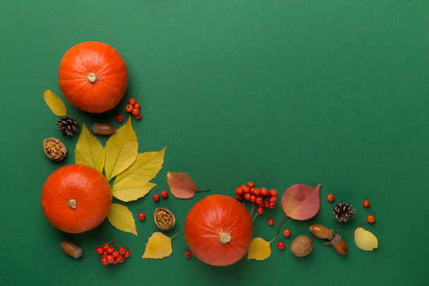 Feestelijke herfst plat lag met pompoenen, bessen en bladeren op kleur achtergrond, bovenaanzicht. - Foto, afbeelding