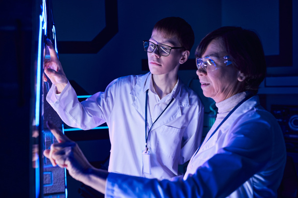 Wissenschaft der Zukunft, Wissenschaftlerin und junge Praktikantin betreiben innovatives Gerät im Entdeckungszentrum - Foto, Bild