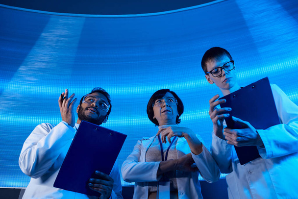 scientifique indien pointant avec les mains près de collègues dans le centre scientifique, orienté vers l'avenir - Photo, image