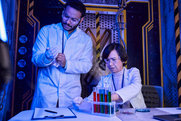 woman scientist working with samples of alien life near indian colleague, futuristic science center - Photo, Image