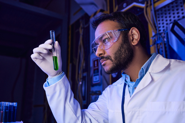 futuristic concept, indian scientist in goggles holding test tube with liquid sample in lab, banner - Photo, Image