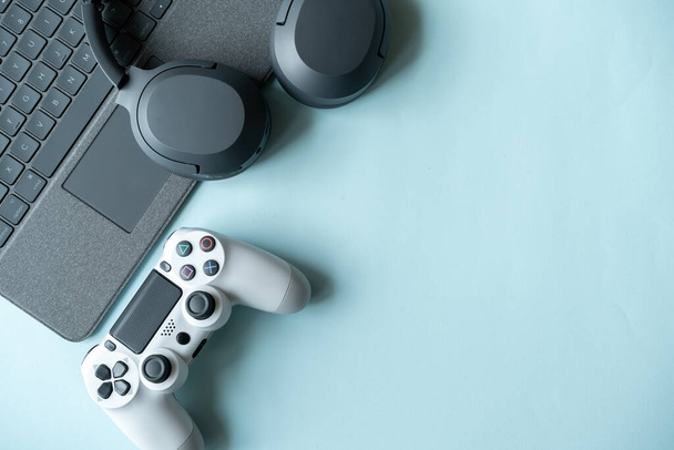 Top view of gaming background with joystick and gamepad, game console, headphones with accessories on blue background ,Online learning design concept. Top view of  ,Top view with copy space for text - Photo, Image