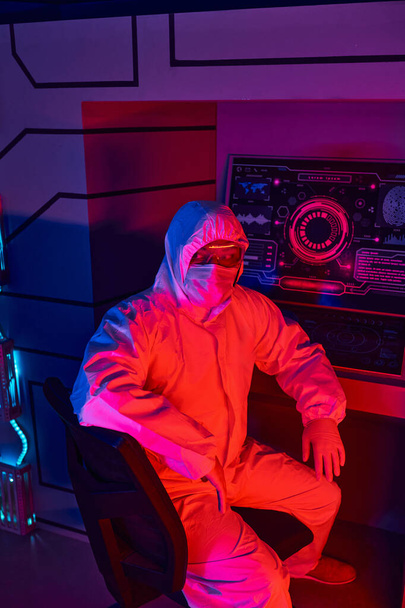 tulevaisuuteen suuntautuva intialainen tutkija hazmat-puvussa istuu kokeellisessa laboratoriossa - Valokuva, kuva