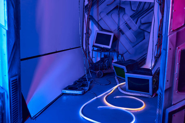 futuristisch concept, computermonitoren en -draden in neon-lit innovatiehub - Foto, afbeelding