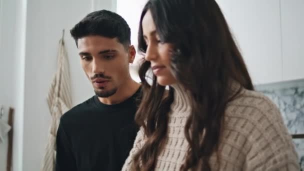 Serious pair talking at kitchen close up. Gentle man looking at gorgeous wife at home. Married couple enjoying time speaking together at cozy apartment. Brunette lady telling to spouse at weekend - Footage, Video