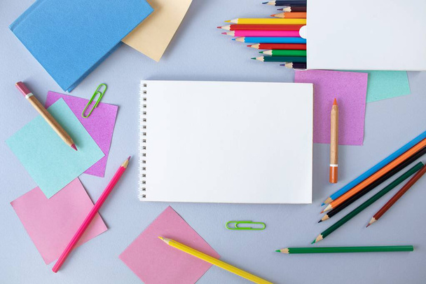 Vissza az iskolába, színes ragacsos jegyzetek és színes ceruzák, szürke kék háttérre rajzolt kellékek fénymásoló hellyel, felülnézet, lapos - Fotó, kép