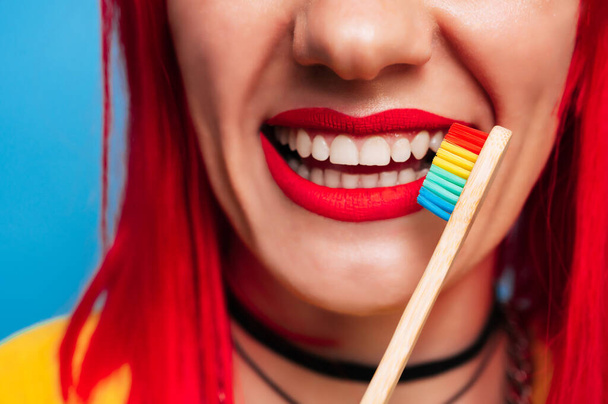 Close-up of a healthy female smile with red lipstick and a toothbrush next to it. The concept of healthy teeth, treatment and oral hygiene - Foto, Imagen