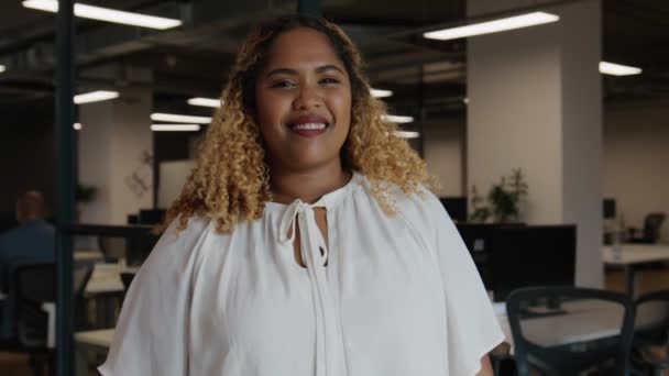 Portrait of happy mid adult black woman in businesswear next to desk in corporate office - Materiał filmowy, wideo