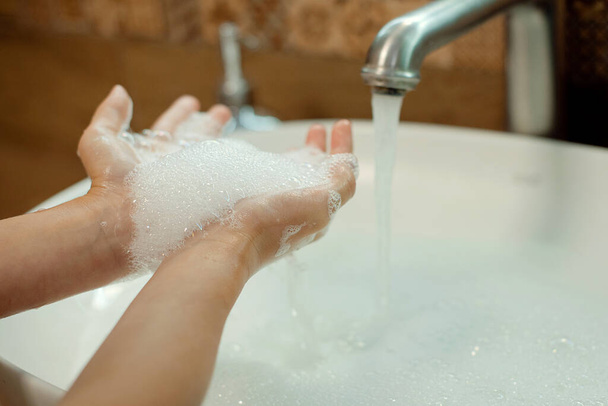 Mytí rukou vodou a mýdlem v koupelně. Hygiena rukou a prevence virových infekcí - Fotografie, Obrázek