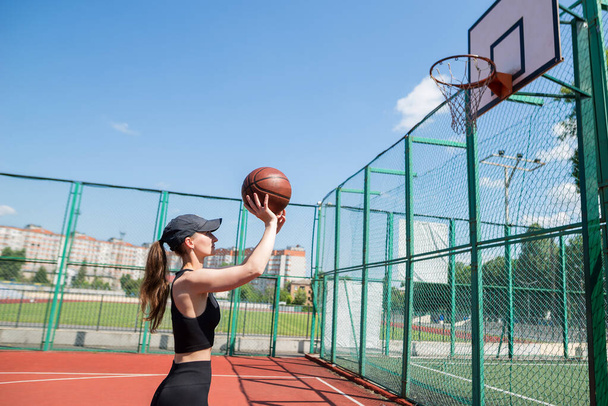 アスレチック女子バスケットボール選手がボールをネットに投げる. - 写真・画像