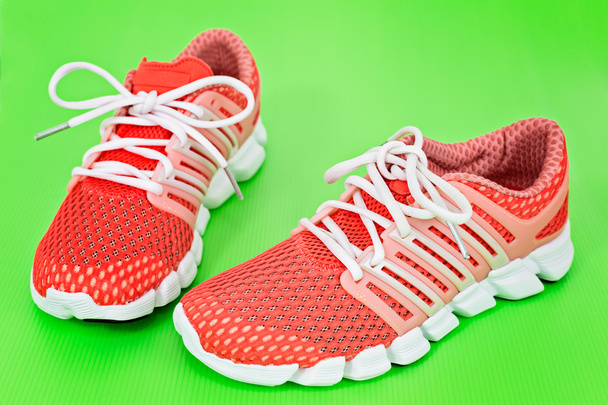 Нове оранжеве та біле бігове взуття, кросівки або тренери на реггі
 - Фото, зображення