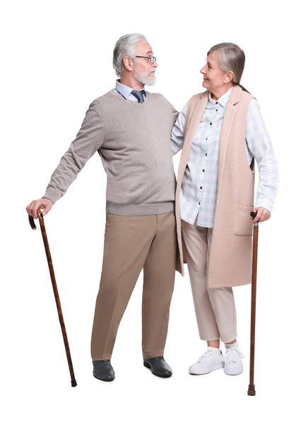 Senior man and woman with walking canes on white background - Fotó, kép