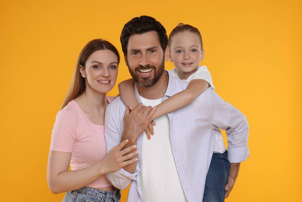 Portrait of happy family on orange background - Fotoğraf, Görsel