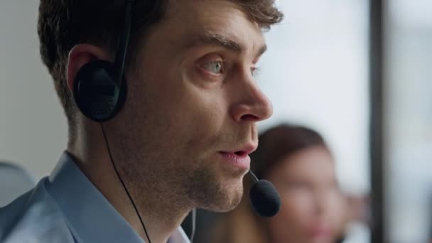 Portrait call center specialist talking microphone. Focused man helping client with technical instructions. Serious professional sales agent consulting speaking in headset. Confident assistant on call - Footage, Video