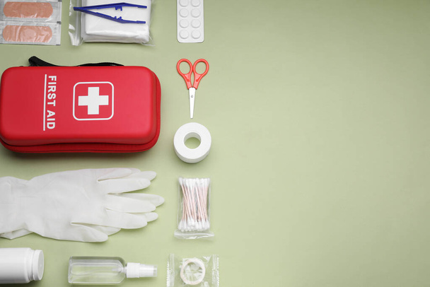 Flat lay composition with first aid kit on light green background, space for text - Foto, Imagen