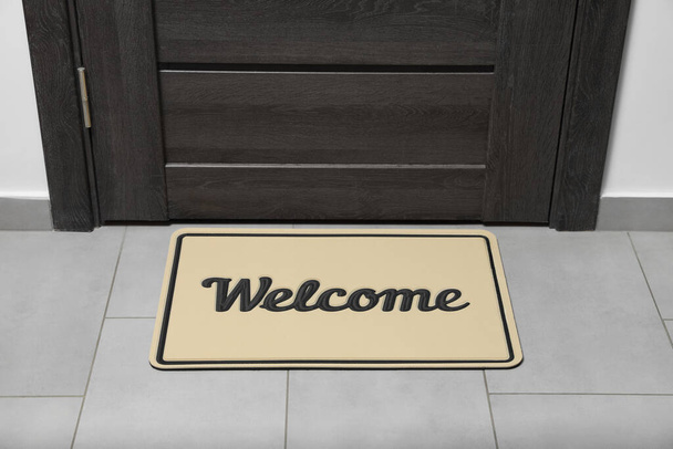 Beautiful beige doormat with word Welcome on floor near entrance - Foto, Imagem