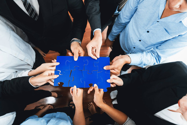 Top view multiethnic business people holding jigsaw pieces and merge them together as effective solution solving teamwork, shared vision and common goal combining diverse talent. Meticulous - Photo, Image