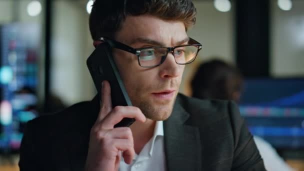 Closeup serious businessman call client in dark office. Thoughtful man manager working late discussing stock market business problem in phone conversation. Busy professional thinking sales strategy - Footage, Video